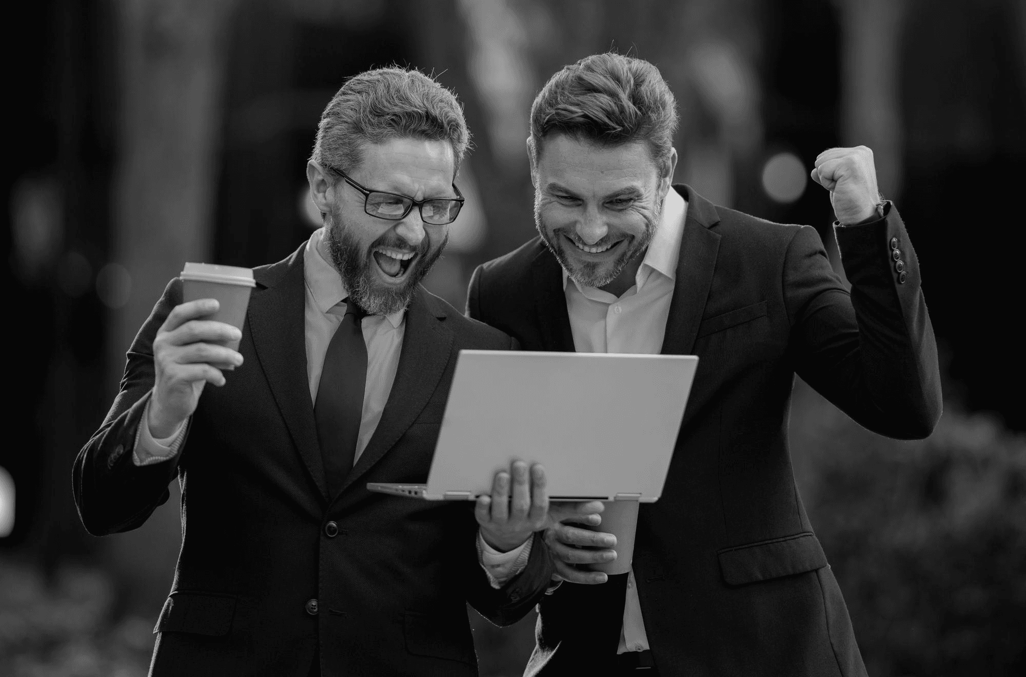 Business professionals celebrating with a laptop